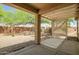 View from covered patio to low-maintenance backyard, neutral rocks, shade trees, and privacy fence at 20007 N Organ Pipe Dr, Surprise, AZ 85374
