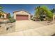 Exterior elevation showcasing the attached two-car garage and meticulously maintained desert landscaping at 20007 N Organ Pipe Dr, Surprise, AZ 85374