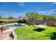 Beautiful backyard pool area with a green grassy area, lounge chairs, and a relaxing hammock at 2106 E Beth Dr, Phoenix, AZ 85042