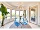 Bright dining room features a modern light fixture, rounded wall of windows and views of the desert landscape at 2106 E Beth Dr, Phoenix, AZ 85042