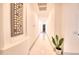 Bright hallway featuring white walls and floors with an art piece and plant to add decor at 2106 E Beth Dr, Phoenix, AZ 85042