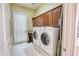 Laundry room with modern washer and dryer units, storage cabinets, and natural light at 2106 E Beth Dr, Phoenix, AZ 85042