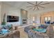 Bright living room features a stone fireplace, large ceiling fan, and comfortable seating at 2106 E Beth Dr, Phoenix, AZ 85042