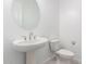 Clean, white powder room featuring pedestal sink and round mirror at 21838 E Bonanza Ct, Queen Creek, AZ 85142