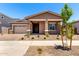 Charming single-story home featuring a two-car garage, covered front porch, and well-kept landscaping in front yard at 21838 E Bonanza Ct, Queen Creek, AZ 85142