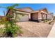 Well-maintained home with an attached two-car garage and inviting covered porch, complemented by a tidy front yard at 21838 E Bonanza Ct, Queen Creek, AZ 85142