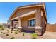 Covered front porch supported by stone columns and surrounded by manicured landscaping enhances the curb appeal at 21838 E Bonanza Ct, Queen Creek, AZ 85142