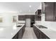 Sleek, modern kitchen with stainless steel appliances, dark cabinetry, and a large center island at 21838 E Bonanza Ct, Queen Creek, AZ 85142