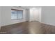 Bedroom featuring hardwood floors, neutral paint, a large window, and two closets at 2318 W Kristina Ave, San Tan Valley, AZ 85144