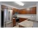 Kitchen featuring stainless appliances, granite counters, wood cabinets, and tile flooring at 2318 W Kristina Ave, San Tan Valley, AZ 85144