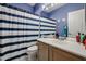Bathroom featuring a shower with blue striped curtain, vanity with sink, and ample counter space at 238 W Marco Polo Rd, Phoenix, AZ 85027