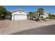Exterior shot of a two-car garage, desert landscaping, and palm trees at 238 W Marco Polo Rd, Phoenix, AZ 85027