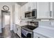 Modern kitchen featuring white cabinets, stainless steel appliances, and durable quartz countertops at 238 W Marco Polo Rd, Phoenix, AZ 85027