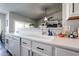 A well-lit kitchen boasts white cabinets, sleek countertops, stainless steel dishwasher, and a view into the living space at 238 W Marco Polo Rd, Phoenix, AZ 85027