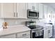 Modern kitchen featuring white cabinets, stainless steel appliances, and durable quartz countertops at 238 W Marco Polo Rd, Phoenix, AZ 85027