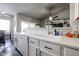 A well-lit kitchen boasts white cabinets, sleek countertops, stainless steel dishwasher, and a view into the living space at 238 W Marco Polo Rd, Phoenix, AZ 85027