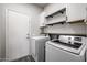 Laundry room featuring washer and dryer units, with white cabinets and shelves above at 238 W Marco Polo Rd, Phoenix, AZ 85027