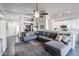 Open-concept living area with a gray sectional, ceiling fan, and modern décor at 238 W Marco Polo Rd, Phoenix, AZ 85027