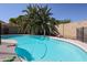 View of the backyard swimming pool surrounded by lush tropical foliage and stone perimeter at 238 W Marco Polo Rd, Phoenix, AZ 85027