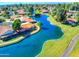 An aerial view of houses with terracotta roofs surrounding a scenic, winding blue lake at 2461 Leisure World --, Mesa, AZ 85206