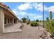 Expansive backyard featuring a patio, desert landscaping, and a serene pond view at 2461 Leisure World --, Mesa, AZ 85206