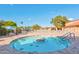 A relaxing community pool with spa, lounge chairs, tables and chairs, shaded area, and surrounded by trees at 2461 Leisure World --, Mesa, AZ 85206