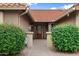 Inviting home entrance with a brick walkway, lush greenery and a cozy porch at 2461 Leisure World --, Mesa, AZ 85206
