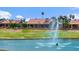 Scenic view of a golf course featuring a water hazard with a fountain and surrounding homes at 2461 Leisure World --, Mesa, AZ 85206