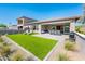 Well-manicured backyard with artificial grass, paved patio, and outdoor seating area at 2885 N 164Th Dr, Goodyear, AZ 85395