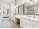 Bright bathroom featuring dual vanities with framed mirrors and modern lighting at 2885 N 164Th Dr, Goodyear, AZ 85395
