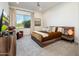 Modern bedroom with large window, ceiling fan, stylish furniture, and ample natural light at 2885 N 164Th Dr, Goodyear, AZ 85395