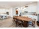 Bright dining area features an elegant table with seating adjacent to a kitchen with white cabinetry at 2885 N 164Th Dr, Goodyear, AZ 85395
