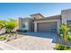 Charming single-story home with a stone-accented facade, desert landscaping, and a stylish garage door with windows at 2885 N 164Th Dr, Goodyear, AZ 85395