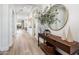 Welcoming foyer with wood flooring, a modern console table, a round mirror, and bright light at 2885 N 164Th Dr, Goodyear, AZ 85395