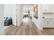Hallway with wood-look floors leading into an open floorplan and featuring white walls and natural light at 2885 N 164Th Dr, Goodyear, AZ 85395