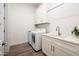 Bright laundry room features front load washer and dryer, storage cabinets, countertop, and a sink at 2885 N 164Th Dr, Goodyear, AZ 85395
