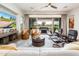 Spacious living room with modern decor, wood floors, a ceiling fan, and large sliding doors that open to the patio at 2885 N 164Th Dr, Goodyear, AZ 85395