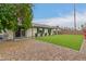 Home's backyard featuring artificial turf, privacy wall, covered patio and well placed shrubbery at 3215 W Phelps Rd, Phoenix, AZ 85053
