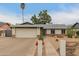 Front exterior of a charming single-story home showcasing drought-resistant landscaping and an attached two-car garage at 3215 W Phelps Rd, Phoenix, AZ 85053
