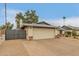 A well-maintained single-story home displaying a large two-car garage and an expansive driveway with desert landscaping at 3215 W Phelps Rd, Phoenix, AZ 85053
