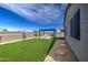 Well-maintained backyard with a verdant lawn, modern pergola, and paved walkway, creating an inviting outdoor space at 33974 N Beeblossom Trl, San Tan Valley, AZ 85144