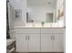 Well-lit bathroom featuring a double sink vanity, framed mirror, white cabinets, and a neutral color scheme at 33974 N Beeblossom Trl, San Tan Valley, AZ 85144