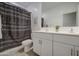 Modern bathroom with a double vanity, framed mirror, patterned shower curtain and tiled floors at 33974 N Beeblossom Trl, San Tan Valley, AZ 85144