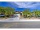 Street view of a single-story home showcasing a two-car garage, desert landscaping, and well-maintained exterior at 33974 N Beeblossom Trl, San Tan Valley, AZ 85144