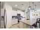 Modern kitchen with stainless appliances, granite counters, white cabinetry, and breakfast bar seating at 33974 N Beeblossom Trl, San Tan Valley, AZ 85144