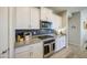 Stylish kitchen featuring white cabinetry, granite countertops, stainless appliances, and elegant backsplash at 33974 N Beeblossom Trl, San Tan Valley, AZ 85144