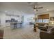 Open-concept living area with tile flooring, a ceiling fan, and seamless flow to the kitchen and dining area at 33974 N Beeblossom Trl, San Tan Valley, AZ 85144