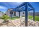 Elegant pergola with outdoor seating and string lights, enhancing the beautifully landscaped backyard at 33974 N Beeblossom Trl, San Tan Valley, AZ 85144