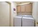 Functional laundry room with a front-load washer and dryer, overhead cabinets, and easy access at 3973 N 160Th Ave, Goodyear, AZ 85395
