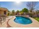 Beautiful backyard pool area with a rock water feature, built in grill, and desert landscaping at 462 S Marie Dr, Chandler, AZ 85225